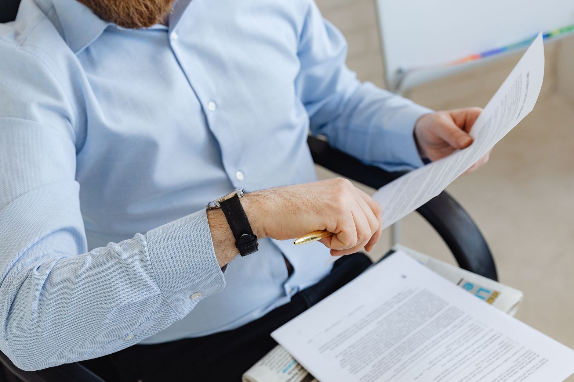 Professional investor reviewing loan documents and rental property financial statements at desk