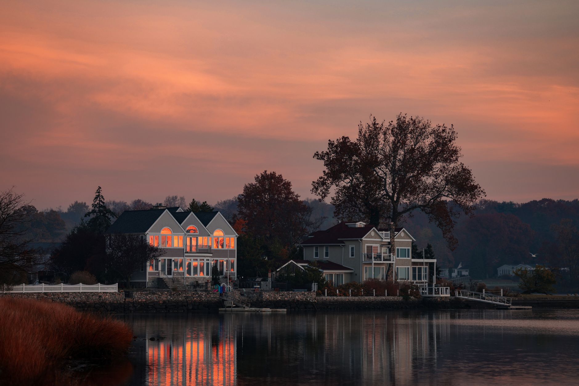 Peaceful lakeside scene at sunset in Stamford, CT with warm sky reflections.