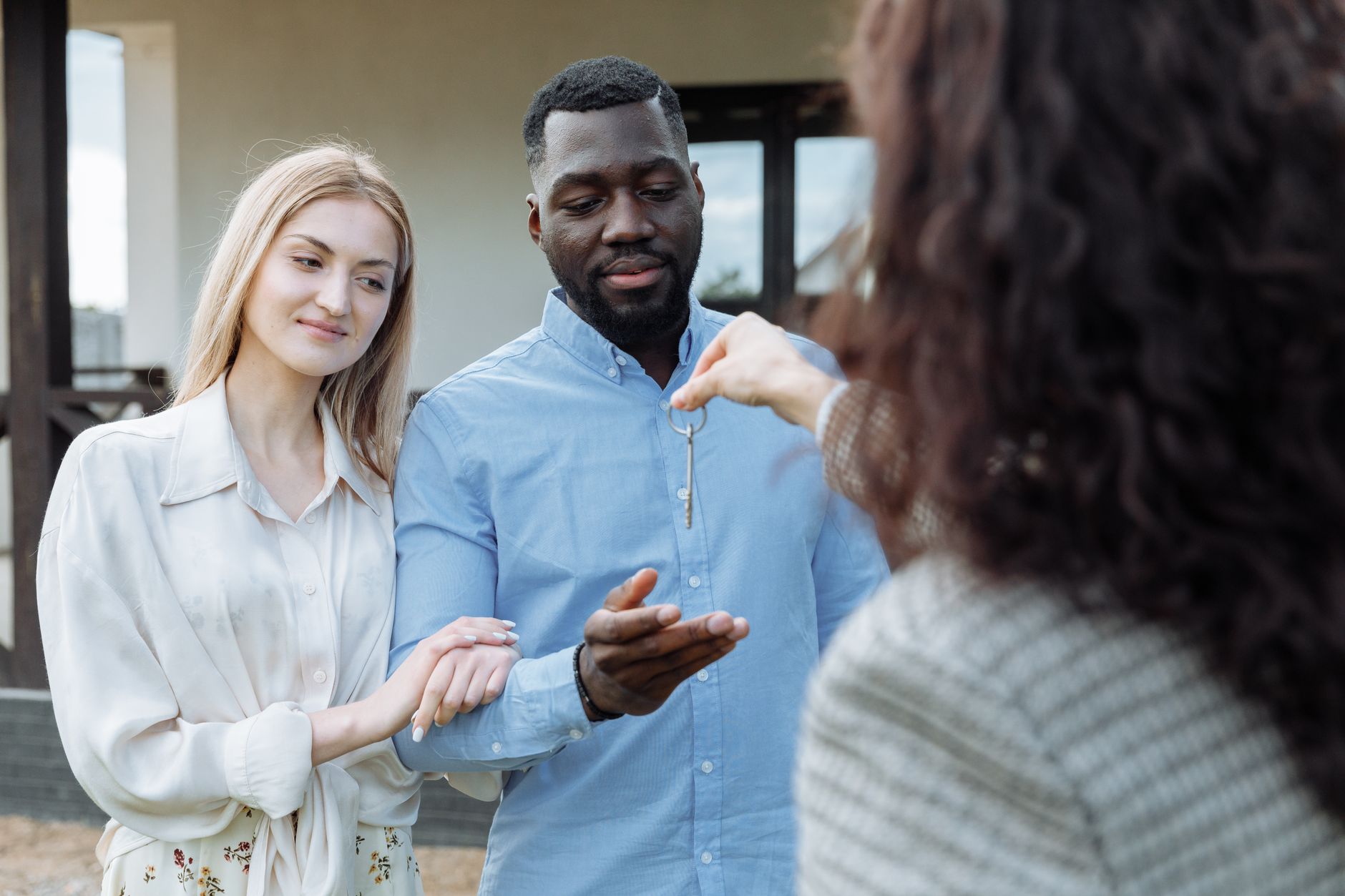 Young family receiving house keys from real estate agent at new home closing