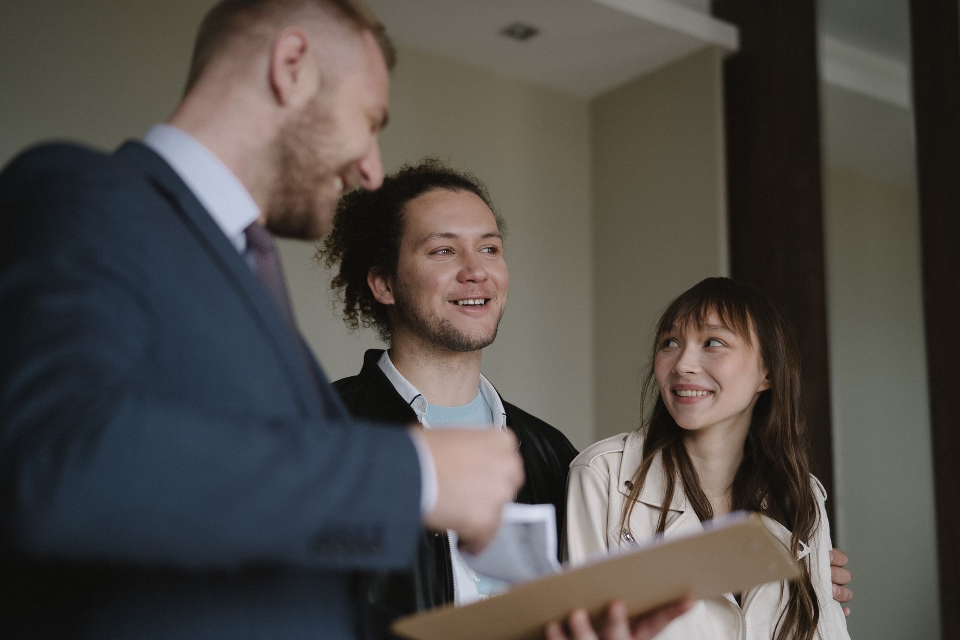 Korean real estate agent discussing property options with clients in modern office setting