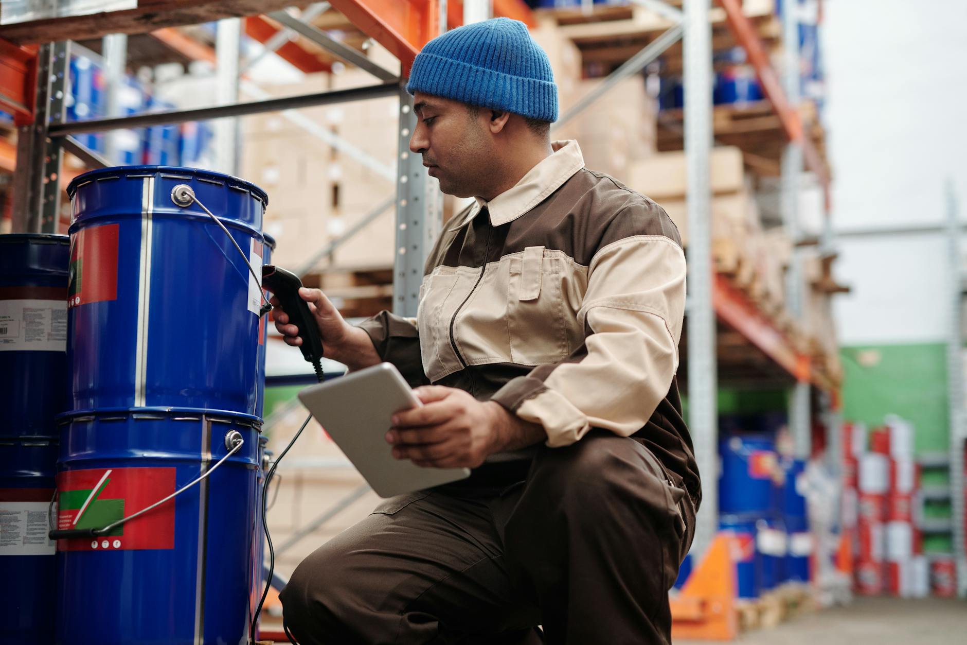 Warehouse worker using tablet to scan and manage inventory boxes in modern logistics facility