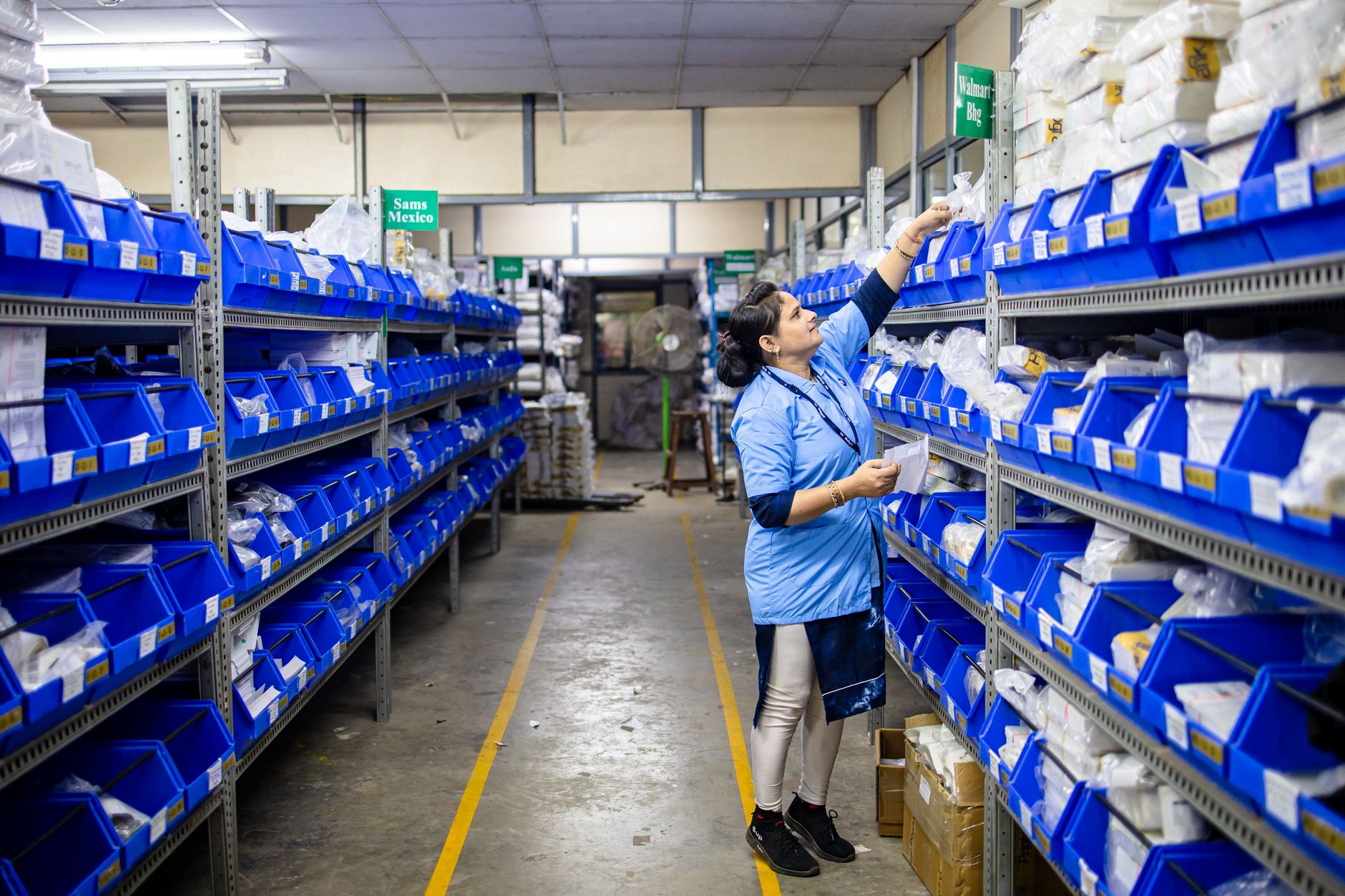 Warehouse worker scanning boxes and managing inventory with digital tablet in modern fulfillment center