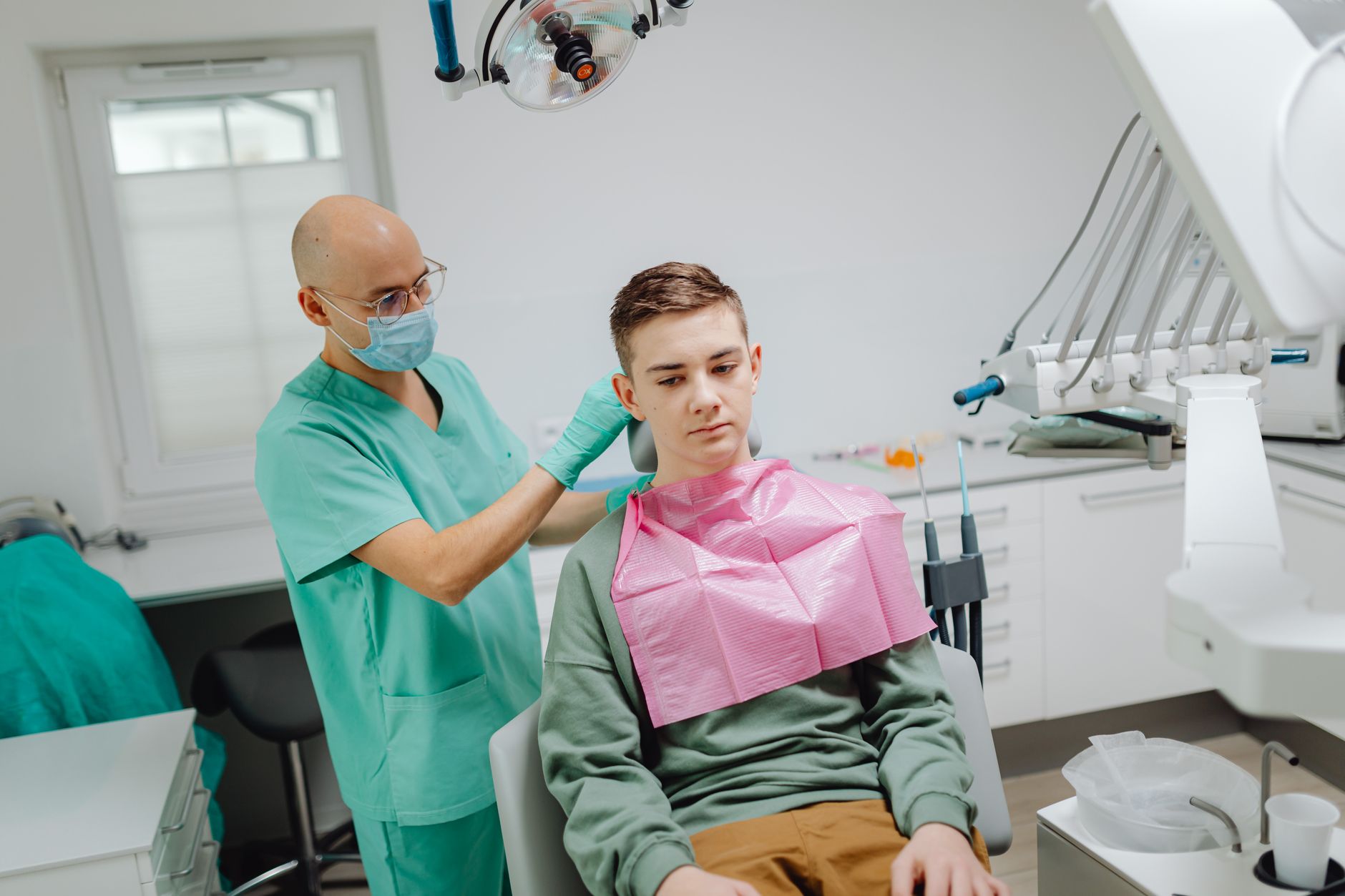 Orthodontist examining young patient's airway and jaw alignment during dental consultation