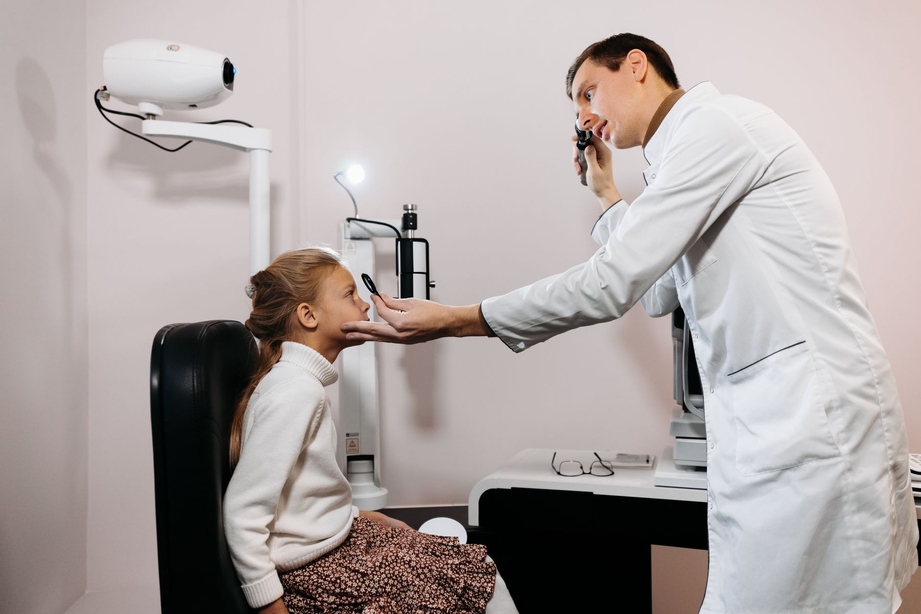 Young child having eyes examined by optometrist during comprehensive eye test
