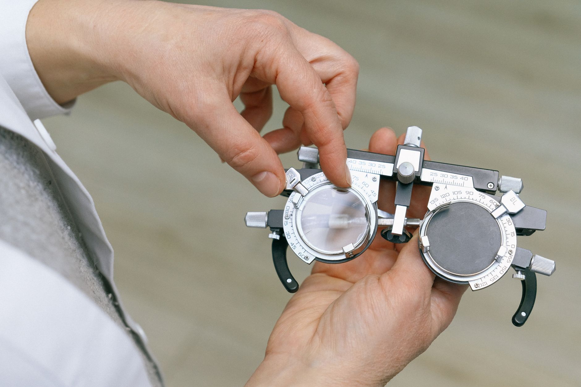 Optometrist fitting a scleral contact lens on a patient's eye during a professional eye examination
