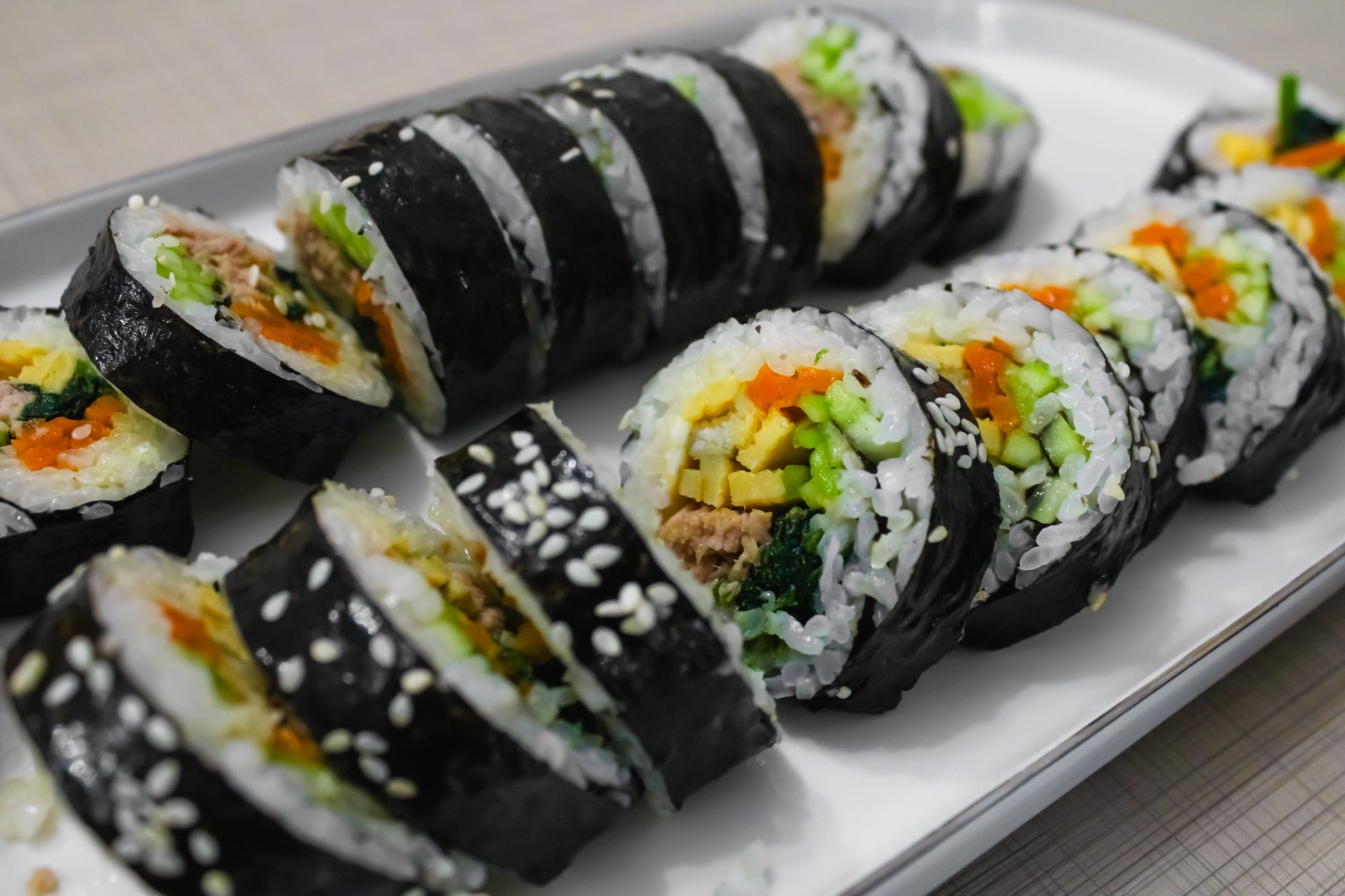 Assorted seaweed snack packages arranged on a clean white surface with fresh vegetables and wellness ingredients nearby