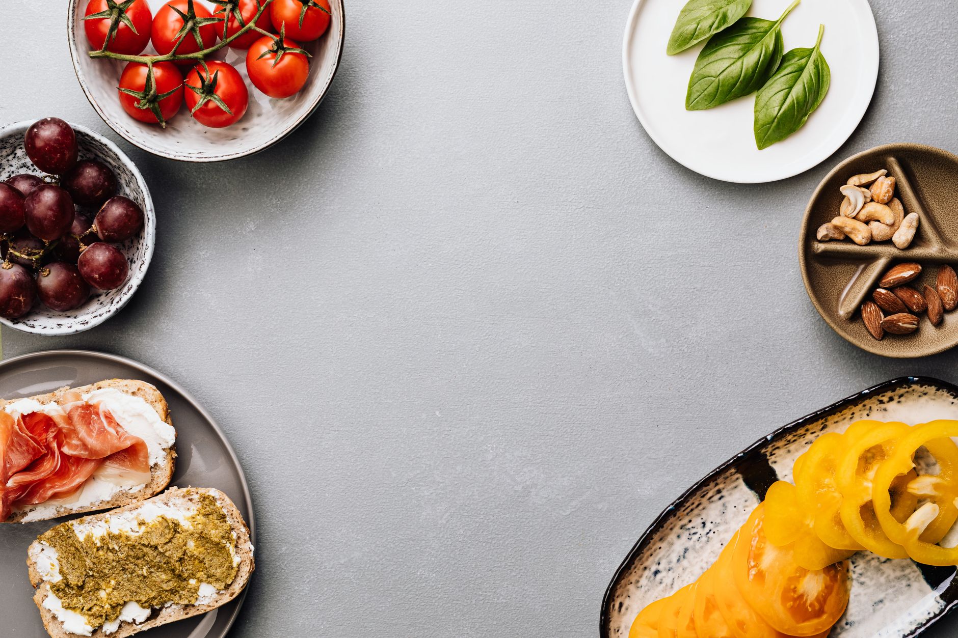 Assortment of nutritious low-calorie snacks arranged on a light background including fresh fruits, vegetables, nuts, and whole grain options