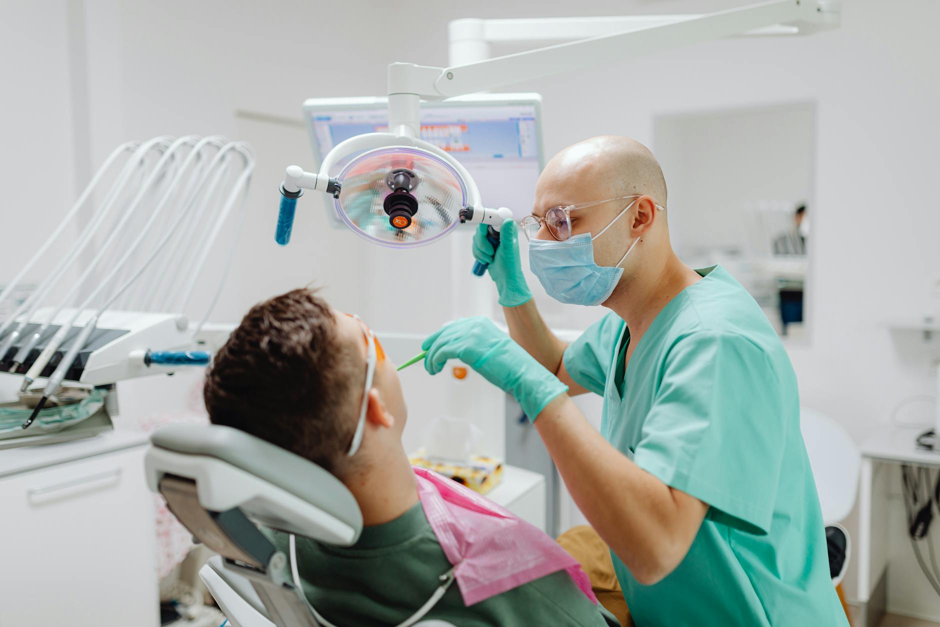 Dentist examining patient's teeth during dental procedure in modern clinic