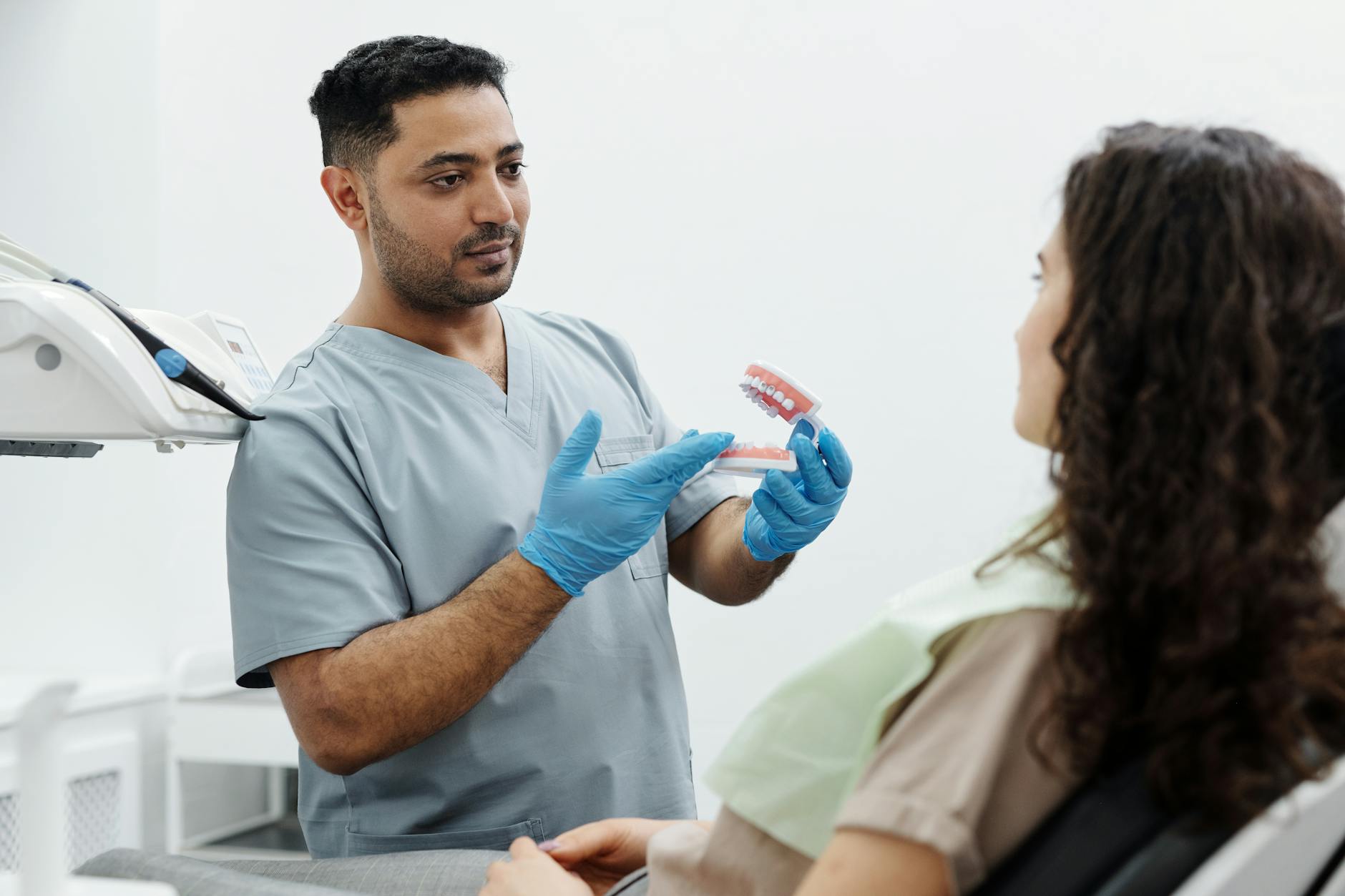 Dentist discussing dental implant pricing and treatment costs with patient in modern dental clinic