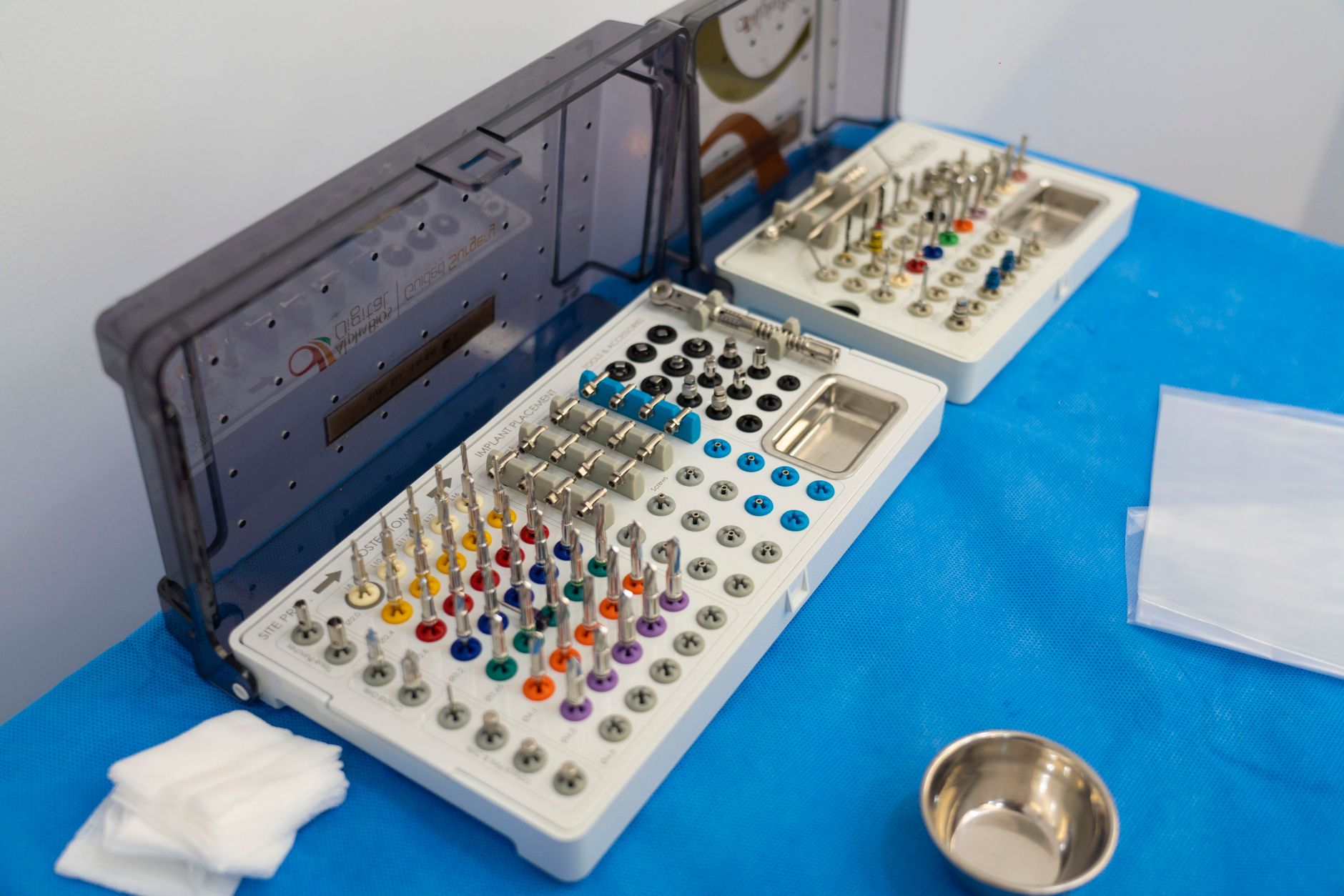 Dentist performing dental implant surgery with anesthesia and surgical instruments in modern dental clinic
