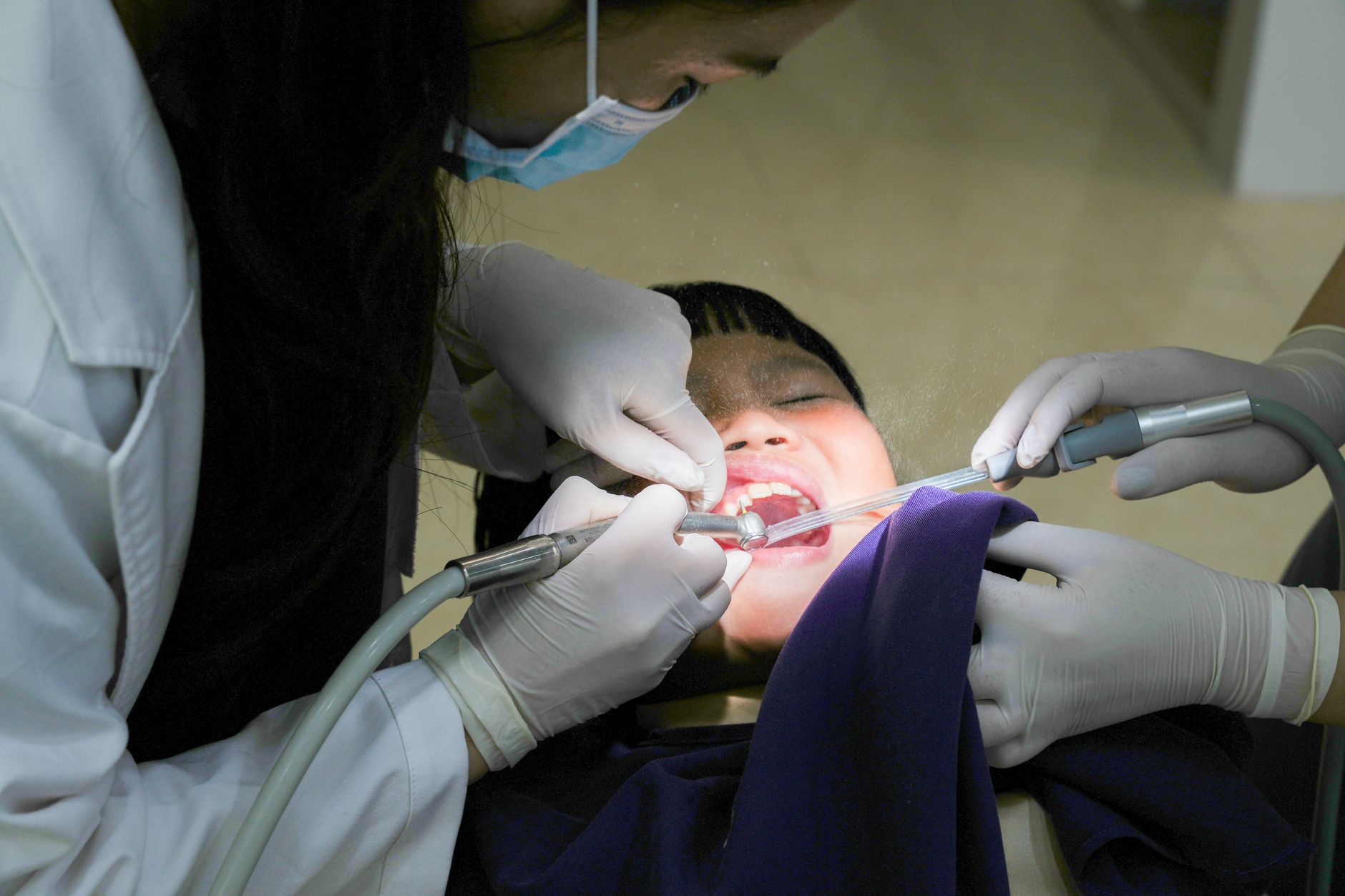 Young child sitting in dental chair during first dental checkup with dentist