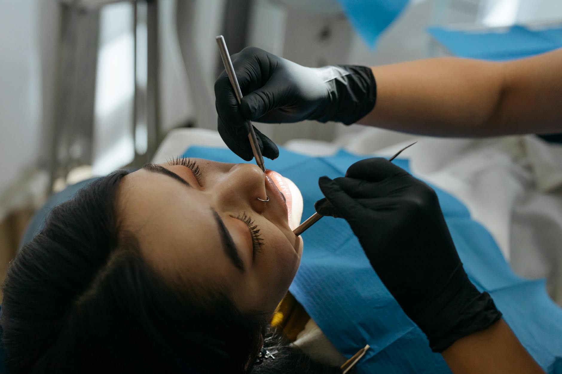 Orthodontist examining patient's teeth during Invisalign consultation in modern dental office