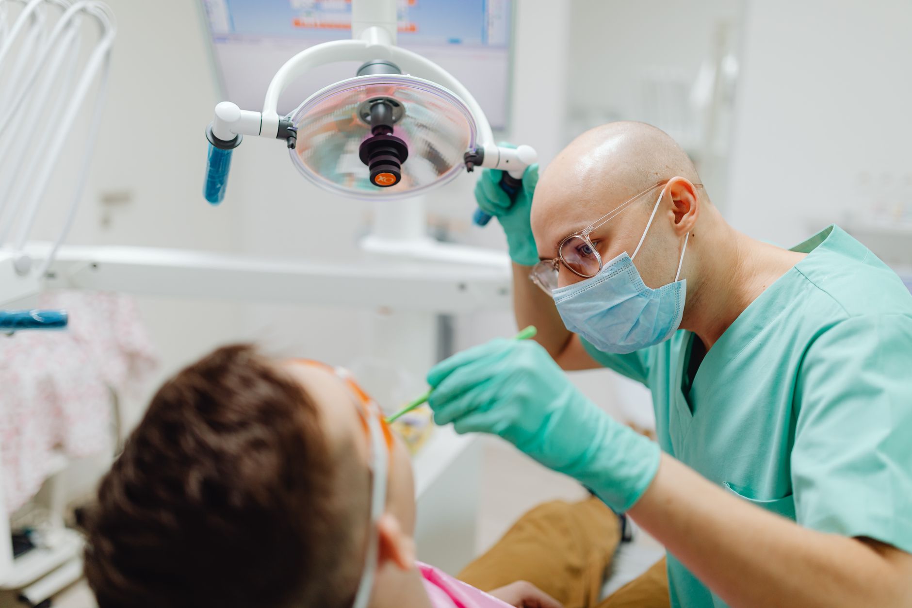 Dentist performing examination on patient in modern dental office with equipment