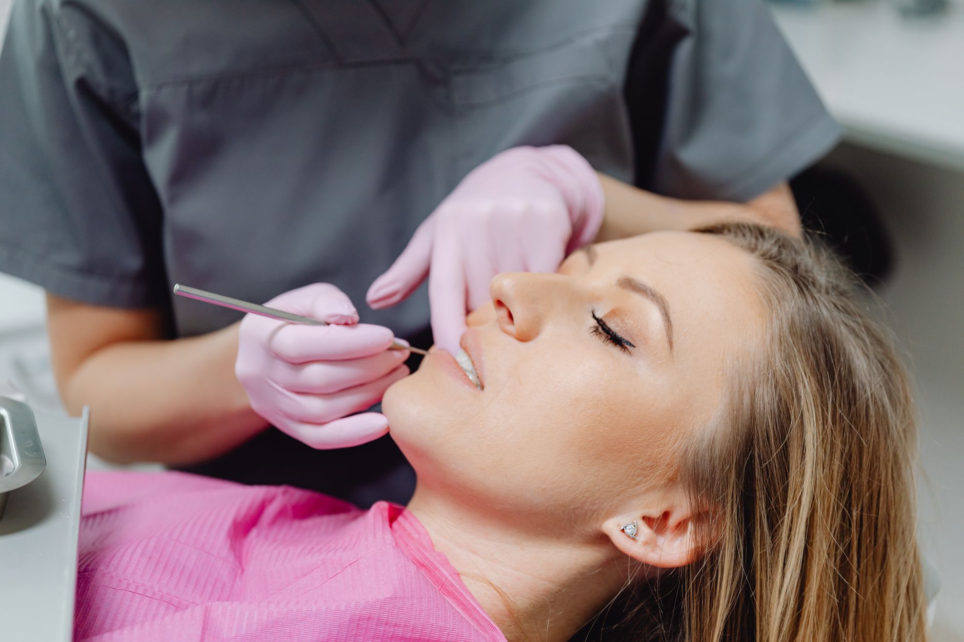 Professional dentist examining patient's teeth during dental implant consultation in modern clinic