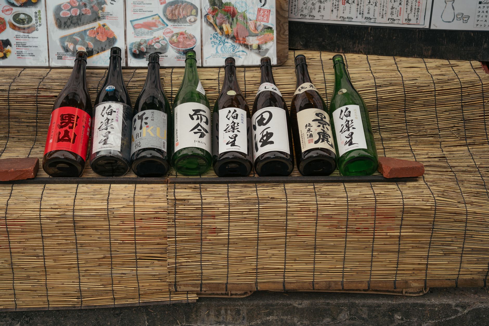 Modern airport lounge with Korean traditional alcoholic beverages displayed on shelves and customers enjoying drinks at tables