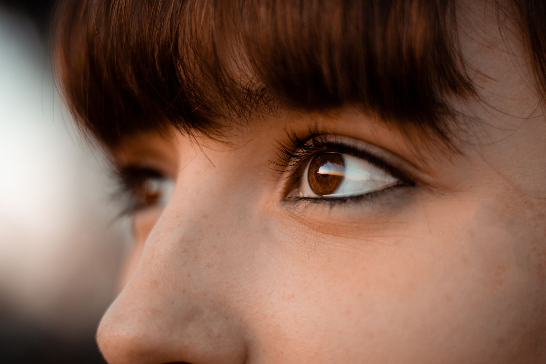 Close-up of a woman's dark brown eyes with subtle colored contact lenses creating a natural shift in eye color