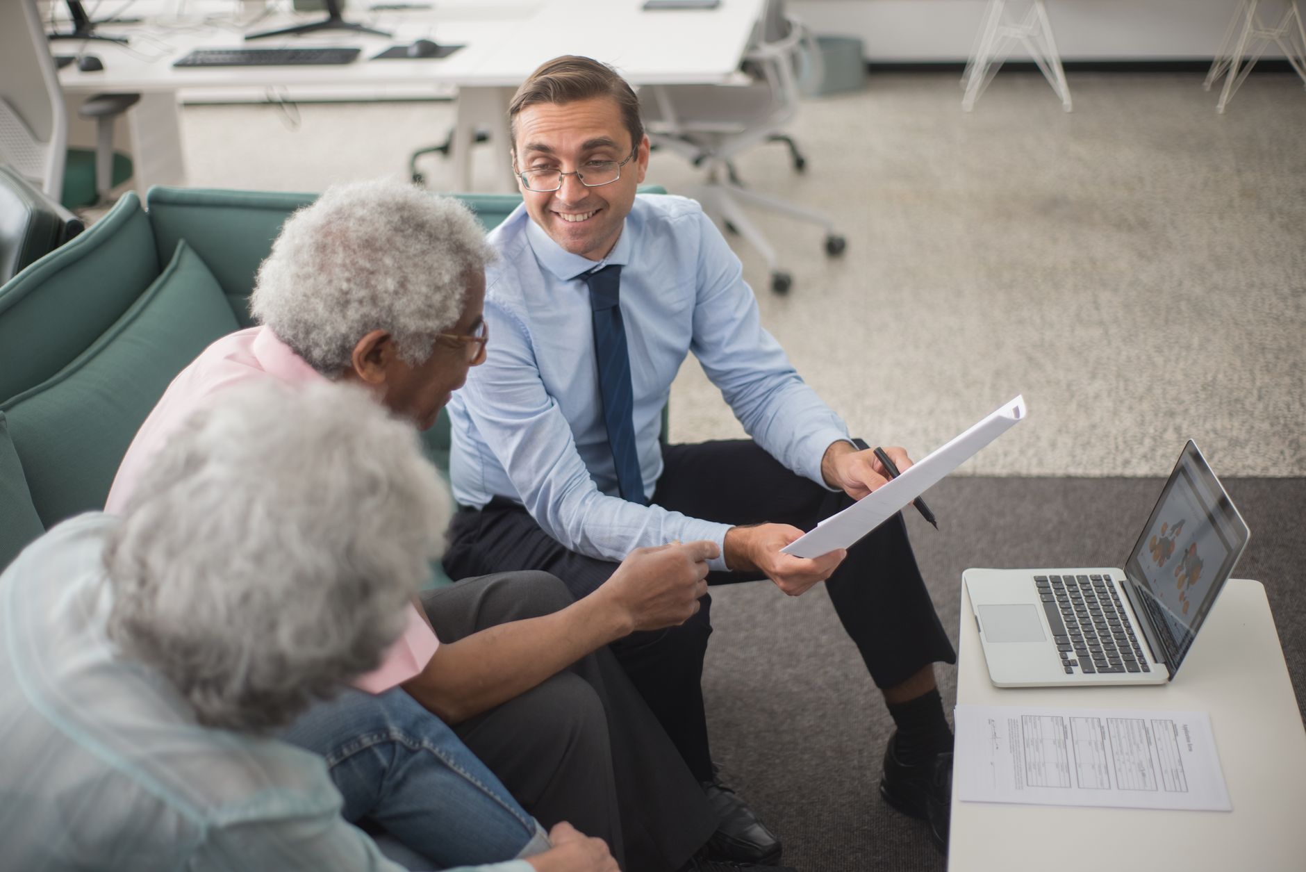 Older Asian couple reviewing insurance documents and paperwork together at home