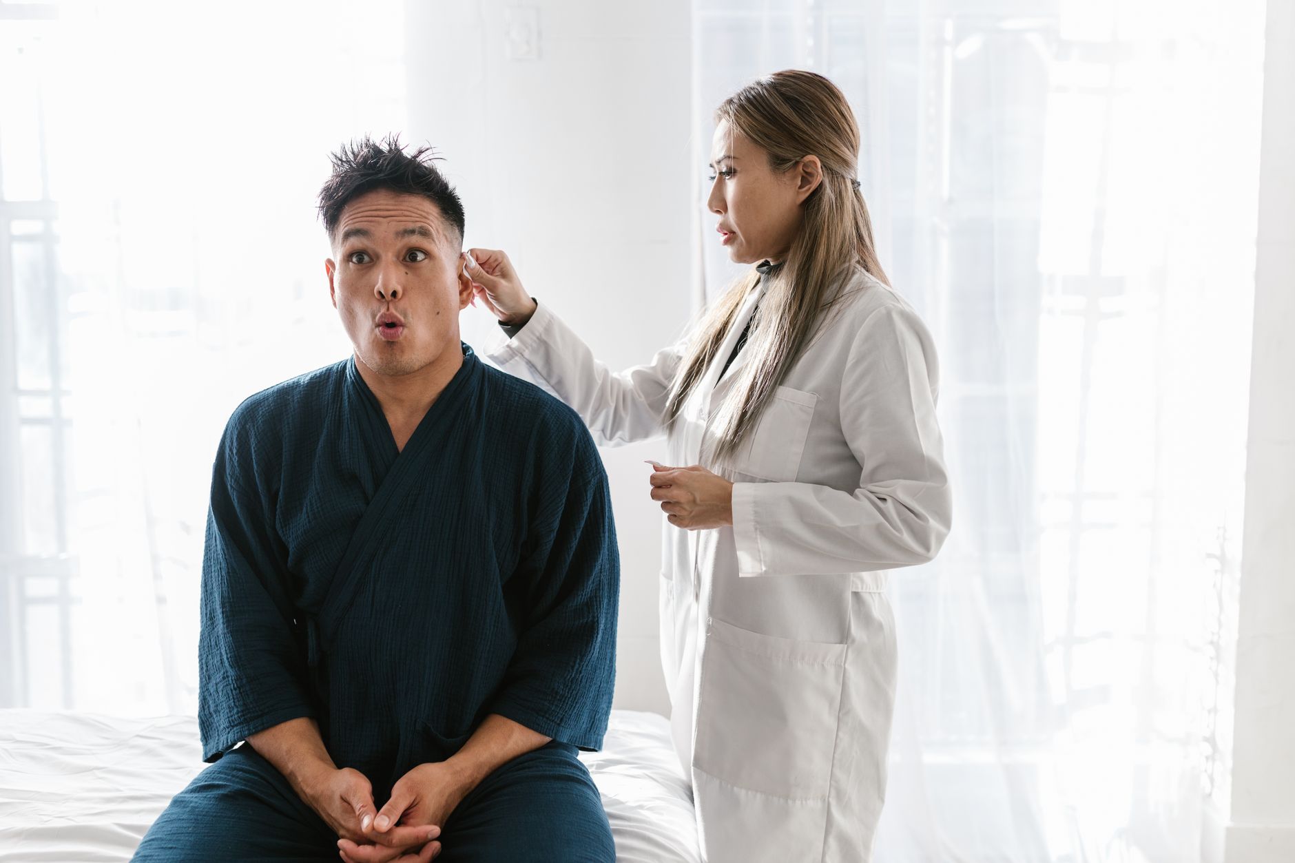 An older Asian woman in conversation with a healthcare professional reviewing medical documents and insurance information together