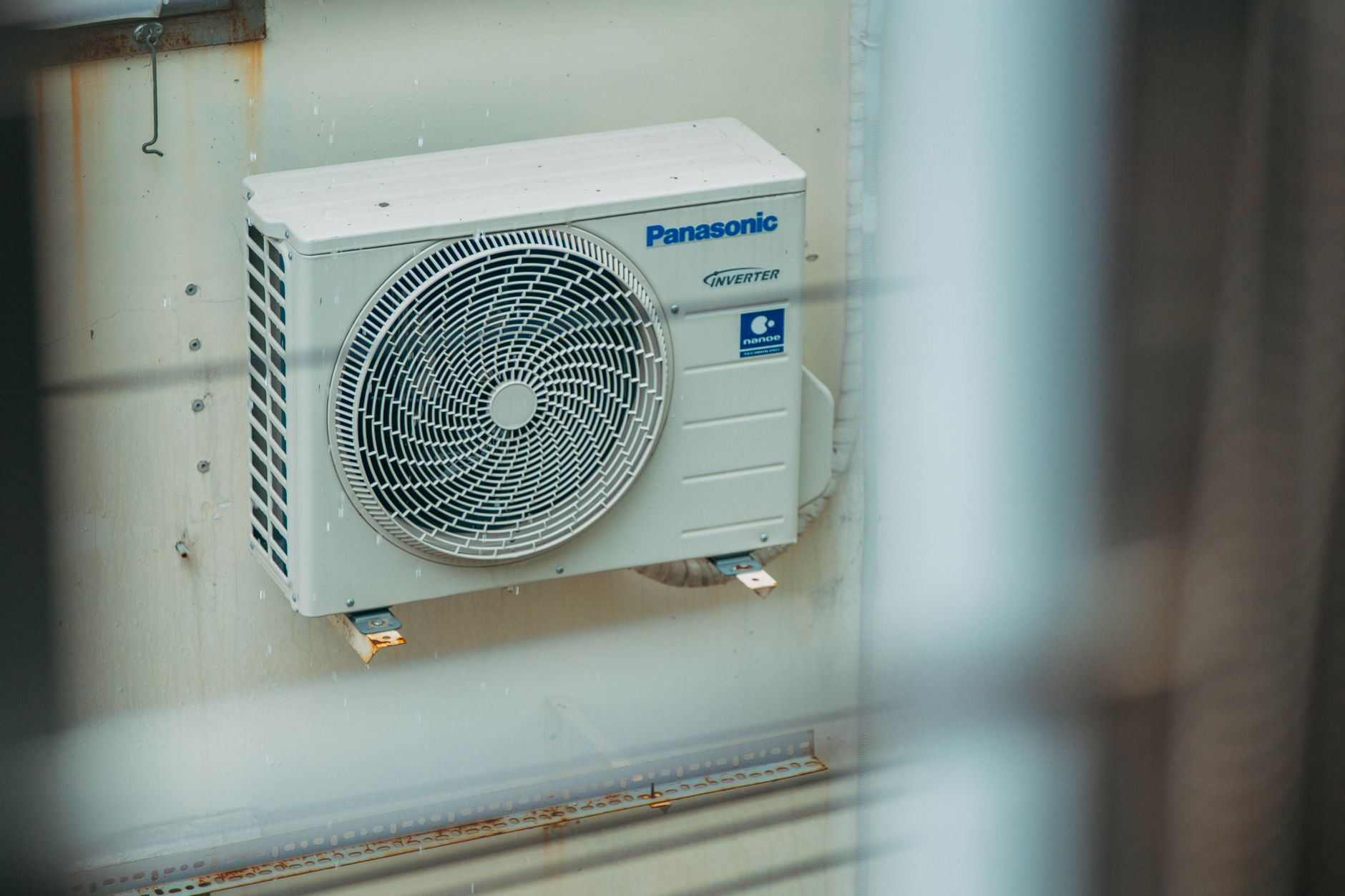 Professional HVAC technician installing a central air conditioning unit on residential home exterior