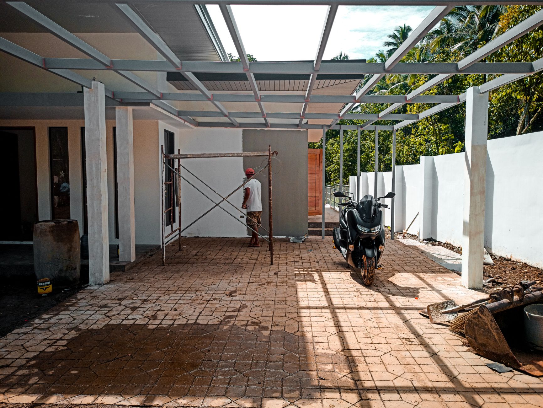 Professional workers installing decorative pavers on a residential patio with stone materials