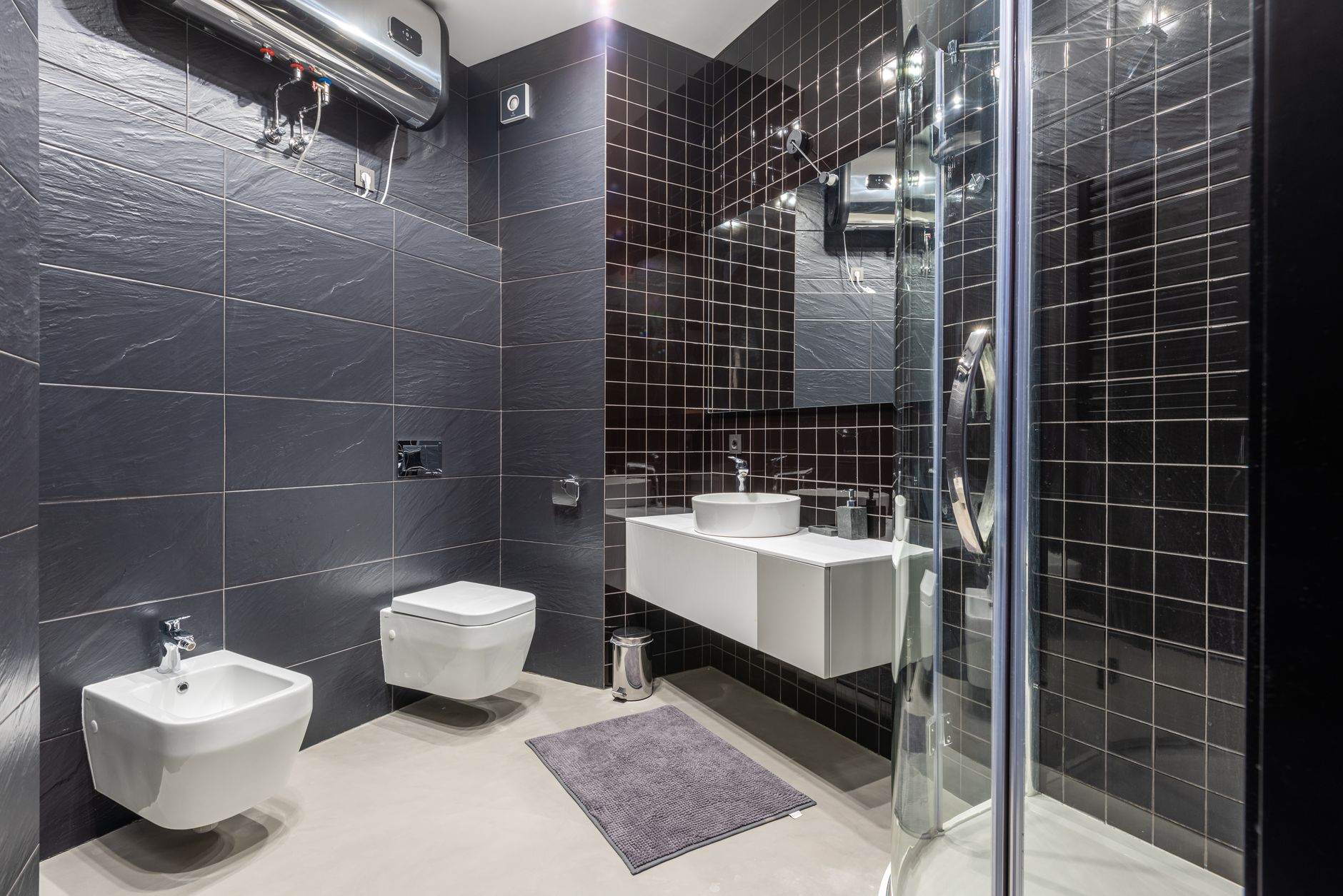 Comparison of modern tankless water heater mounted on wall versus traditional tank water heater in Arizona home