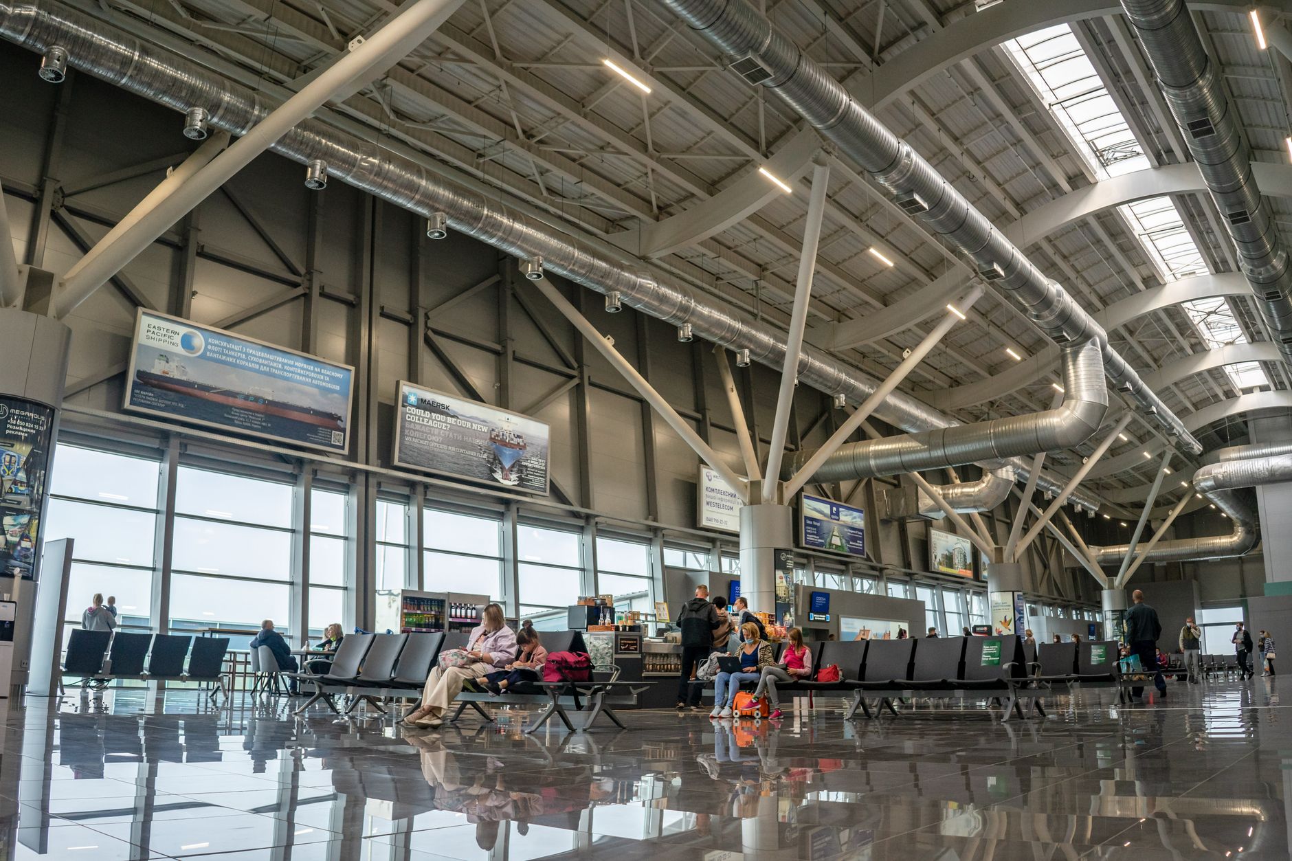 Modern premium airport lounge with comfortable seating, contemporary design, and traveler relaxing before flight