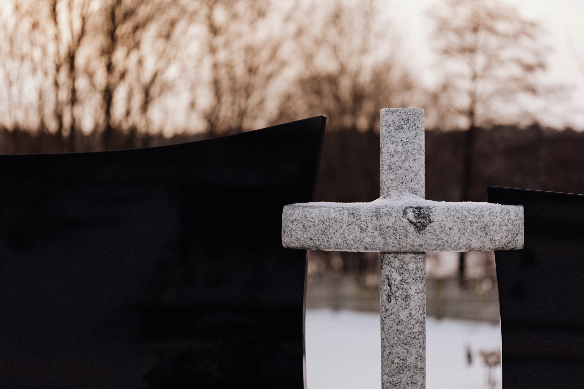 Granite headstone monument displayed in cemetery with foundation base visible