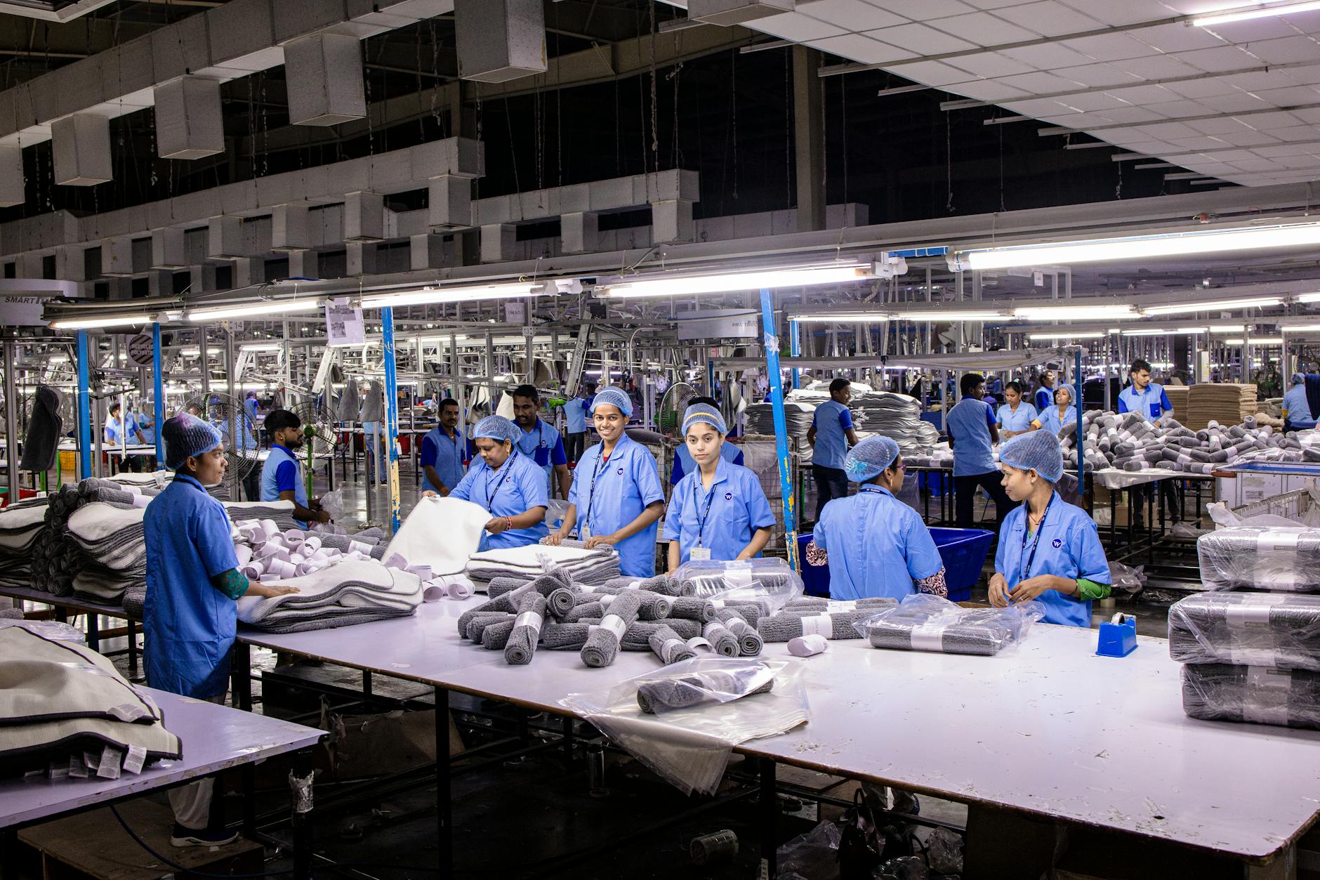 Indian textile factory workers expertly packaging products on an assembly line.