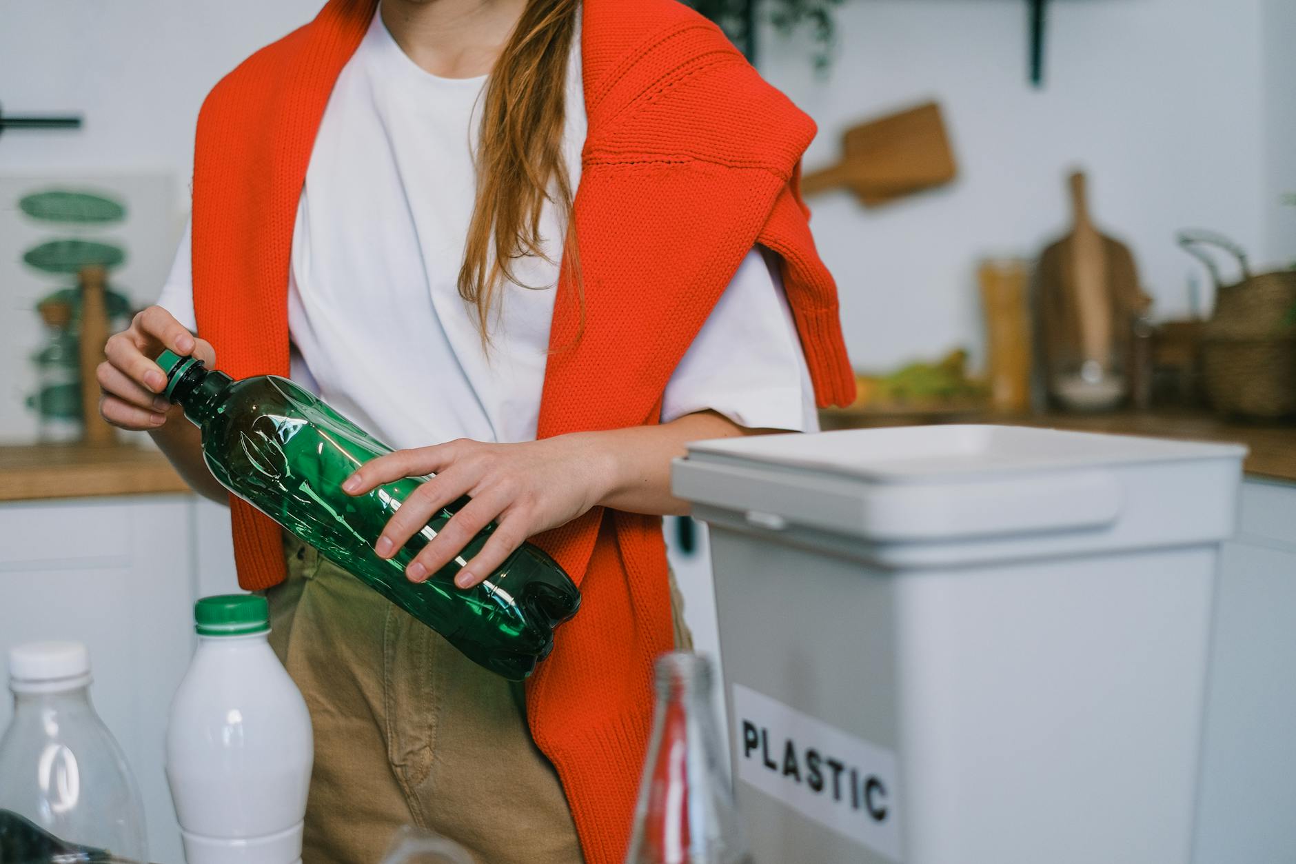 Woman using non-toxic cleaning products to clean kitchen counters and surfaces with eco-friendly supplies