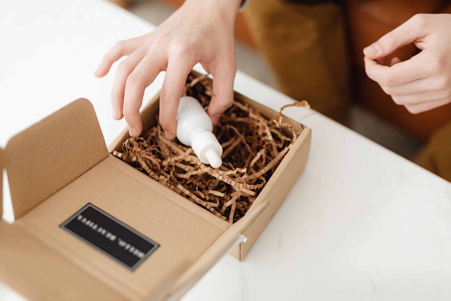 Young content creator unboxing beauty products for social media, recording with smartphone