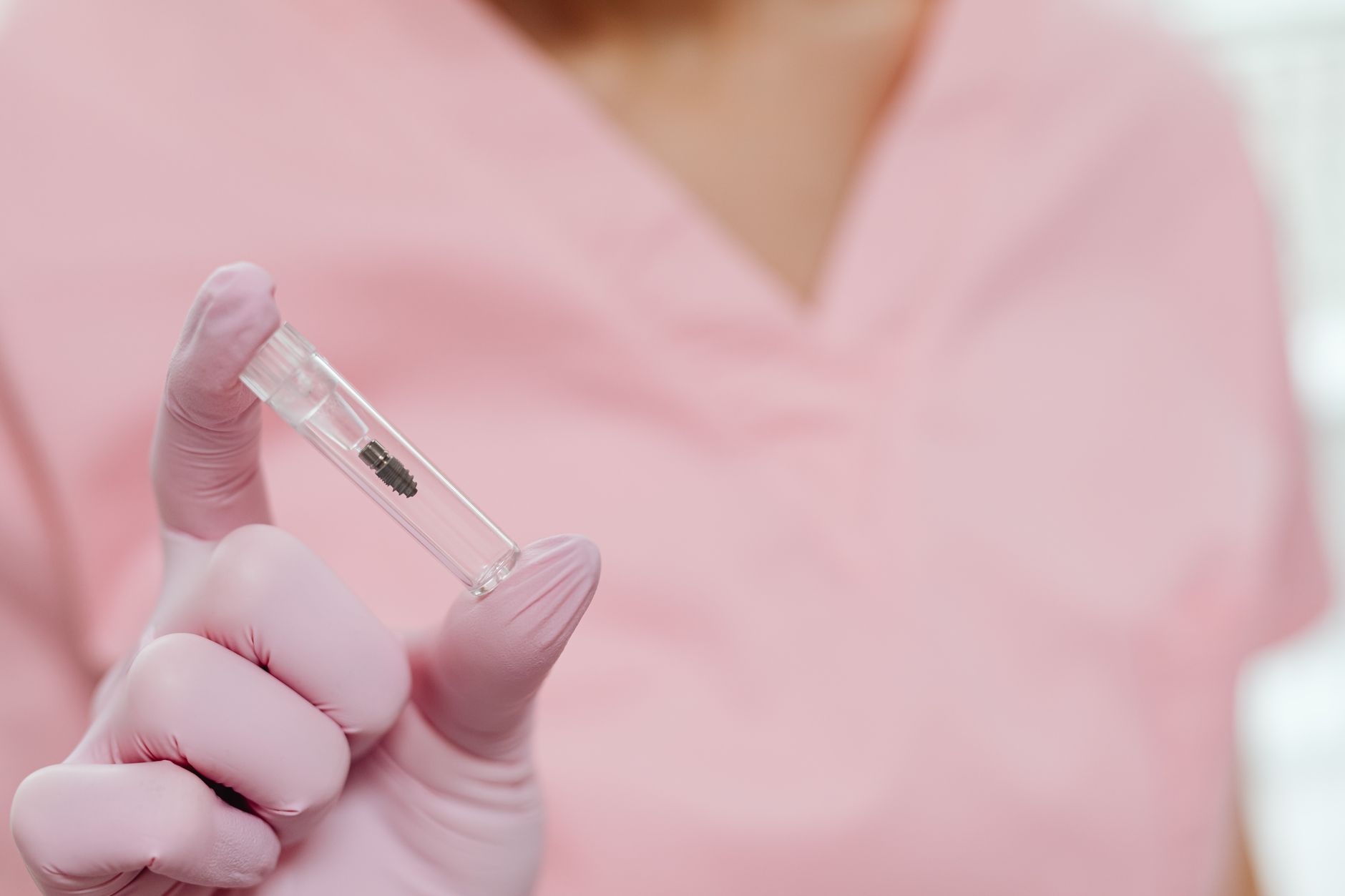 dentist showing dental implant model to patient during consultation