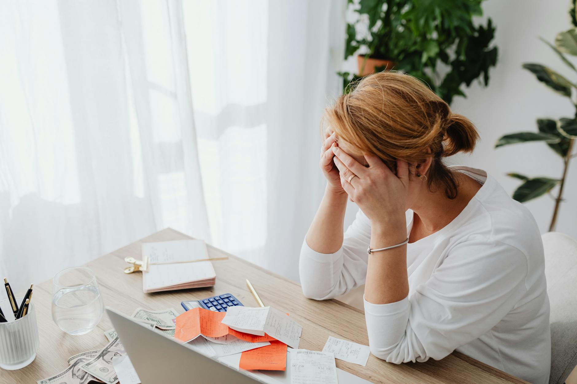 Overwhelmed dentist surrounded by administrative paperwork and patient files at office desk