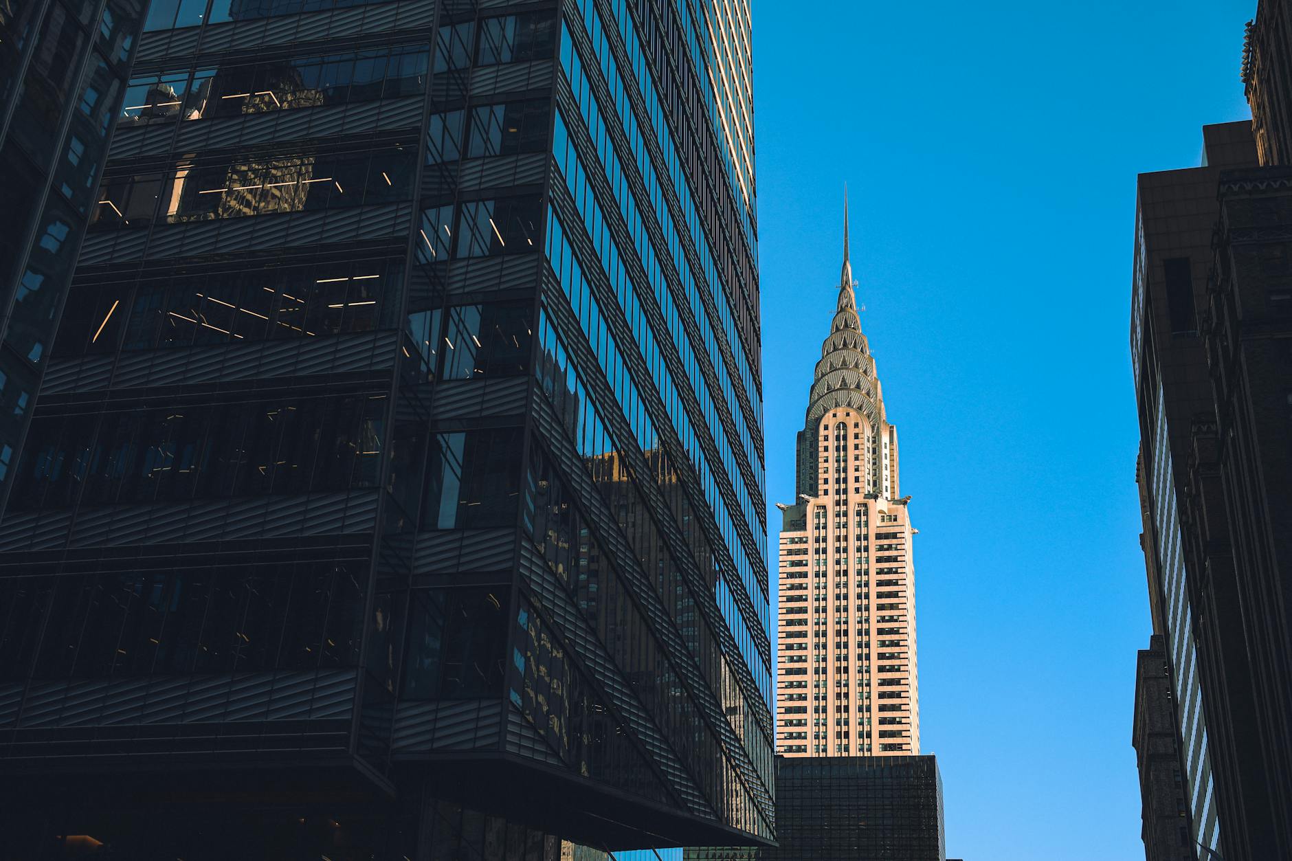 Modern commercial office building in Manhattan with glass facade and city skyline view