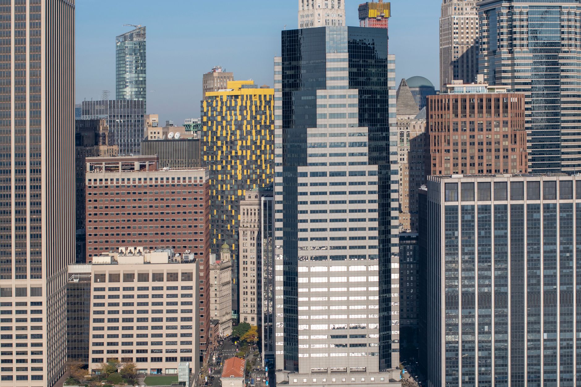 Modern commercial office building in Manhattan with glass facade and urban skyline view