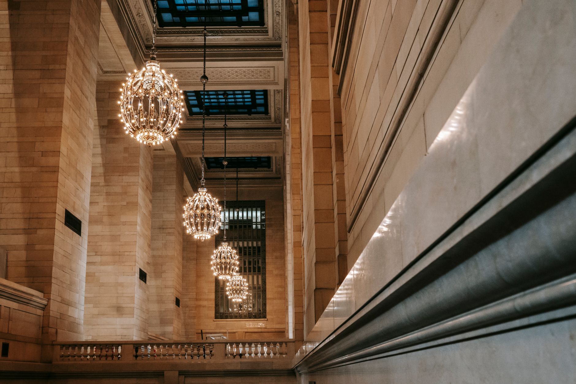 Classic interior of Grand Central Terminal with majestic chandeliers on ornamental ceiling with glass windows under lattice