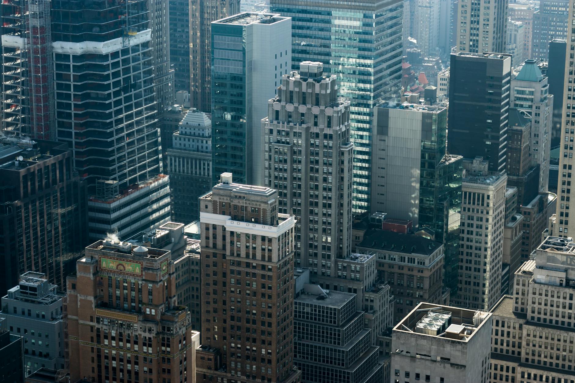 Two professionals shaking hands in a modern NYC office building with city skyline visible through windows