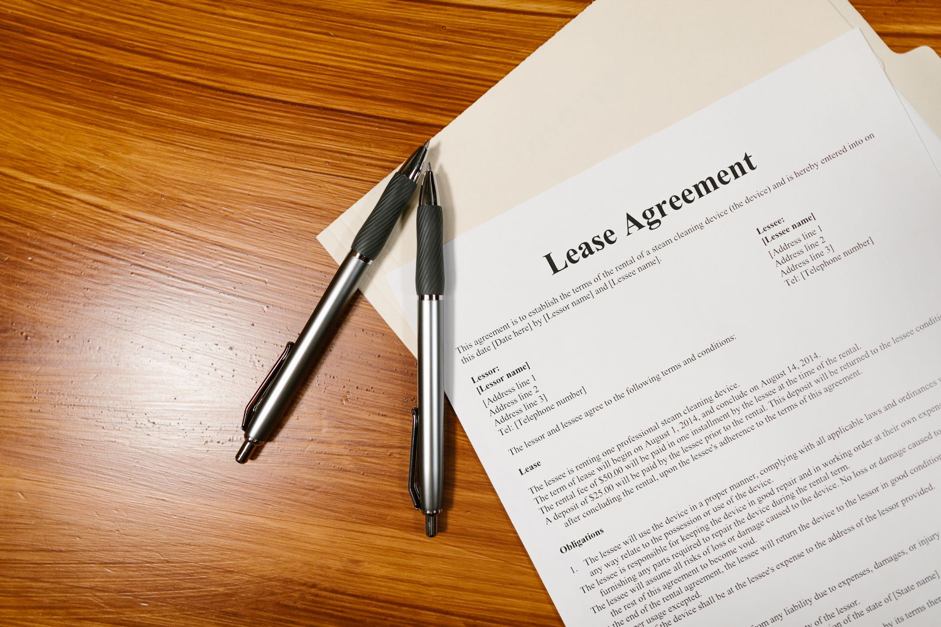 Close-up of rental lease agreements and financial documents spread across a desk with a pen and calculator