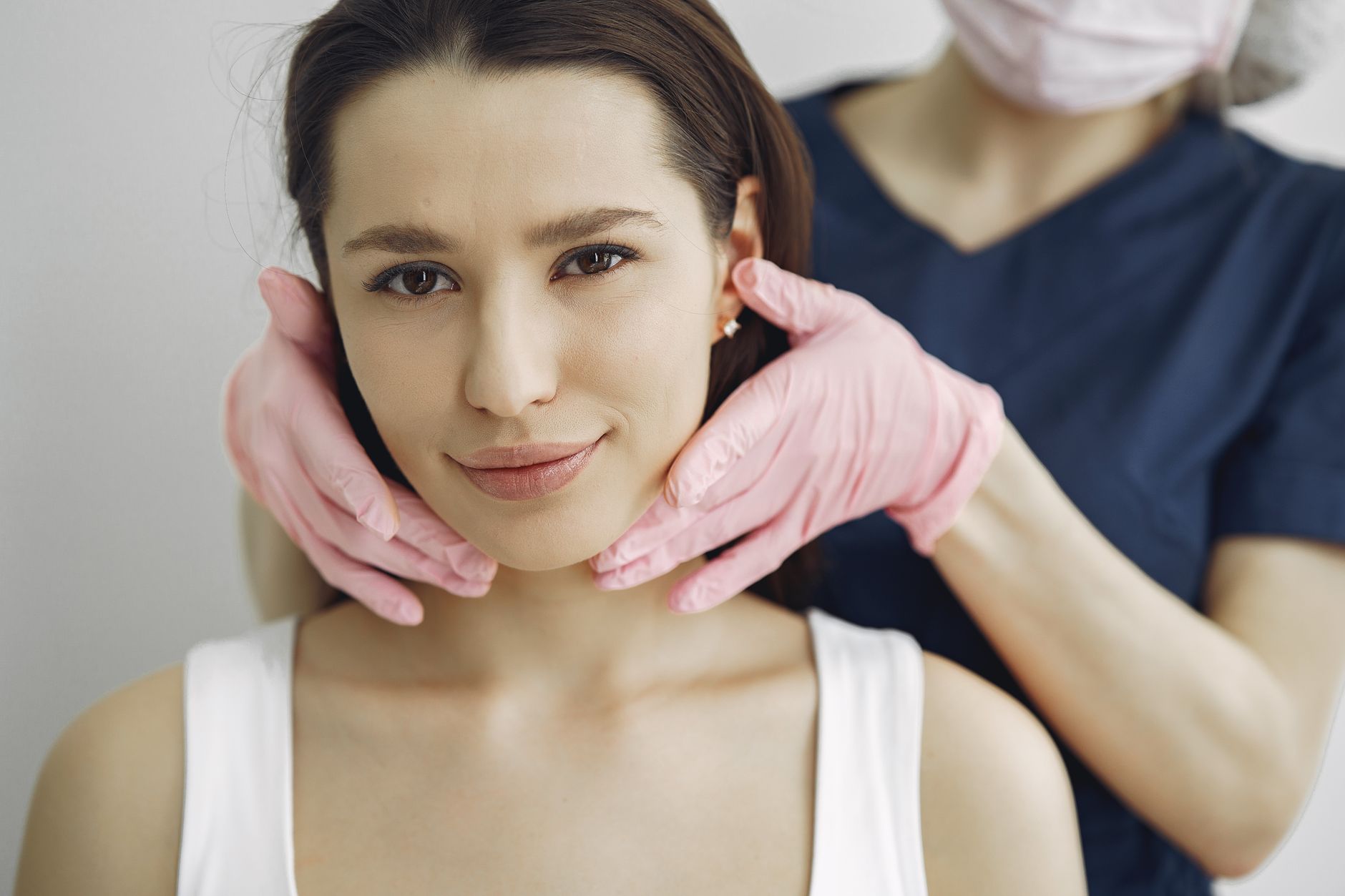 Woman receiving non-invasive jawline tightening treatment with advanced skincare technology