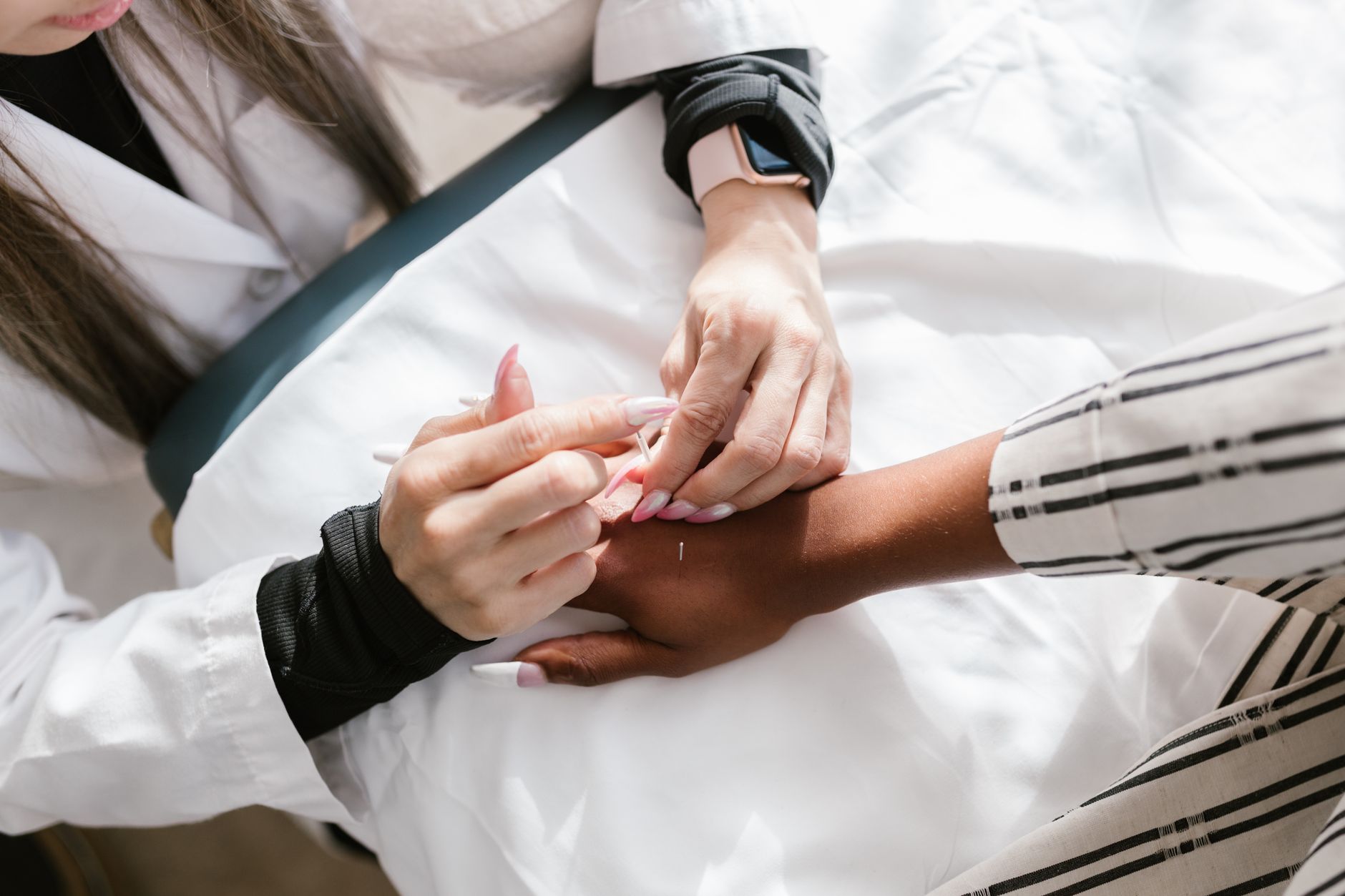healthcare professional performing acupuncture treatment on patient's lower back for chronic pain relief