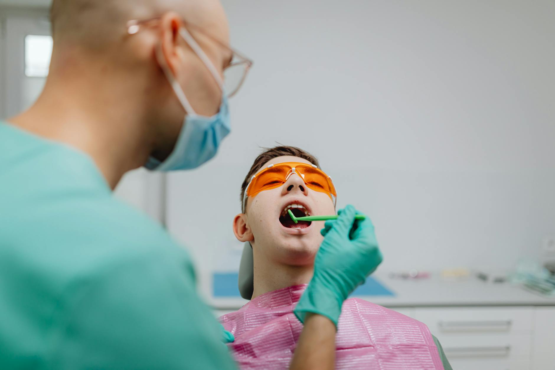 Dentist performing comprehensive examination on patient in modern dental chair with advanced equipment