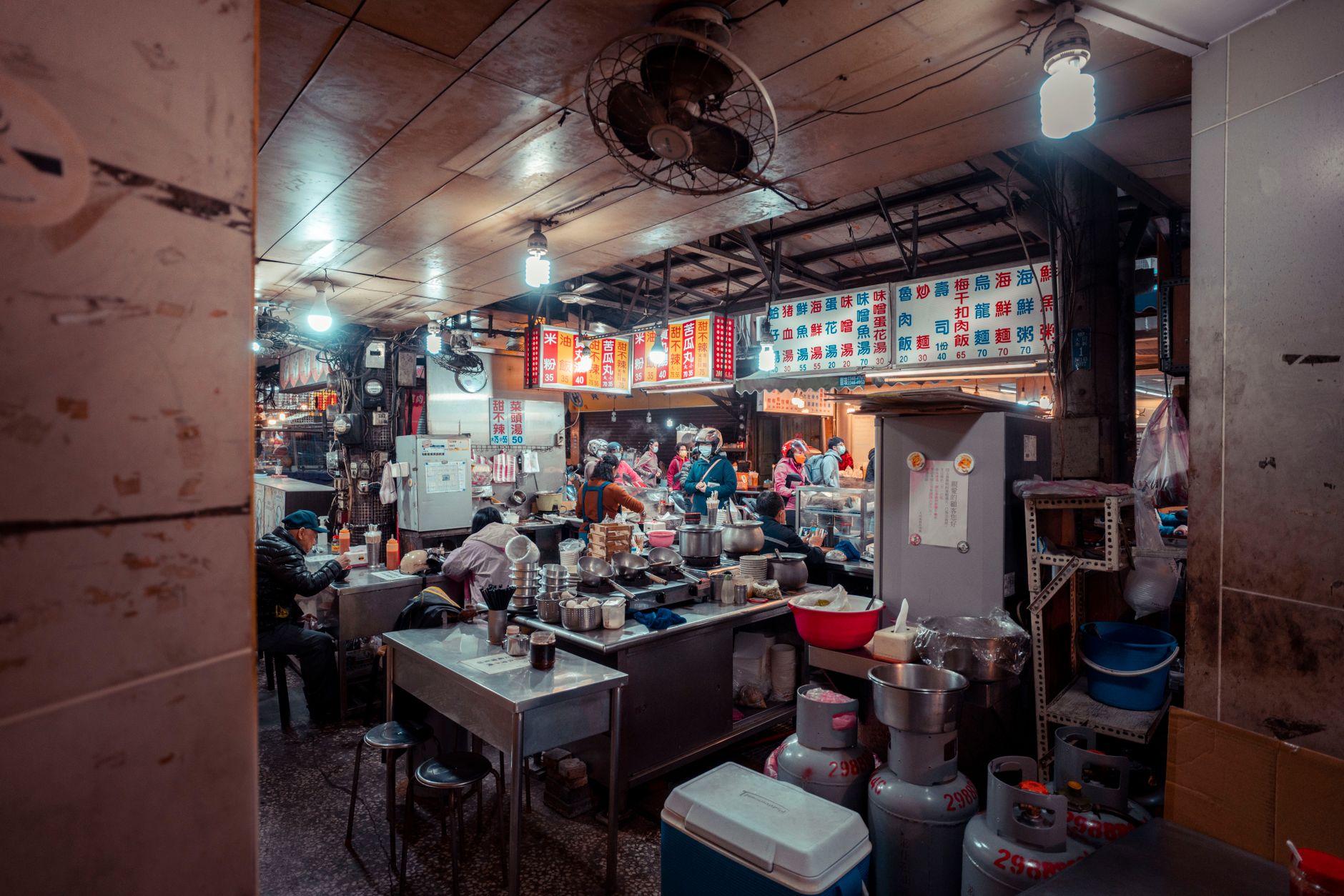 Interior of a traditional Chinese eatery bustling with diners and vibrant decor.