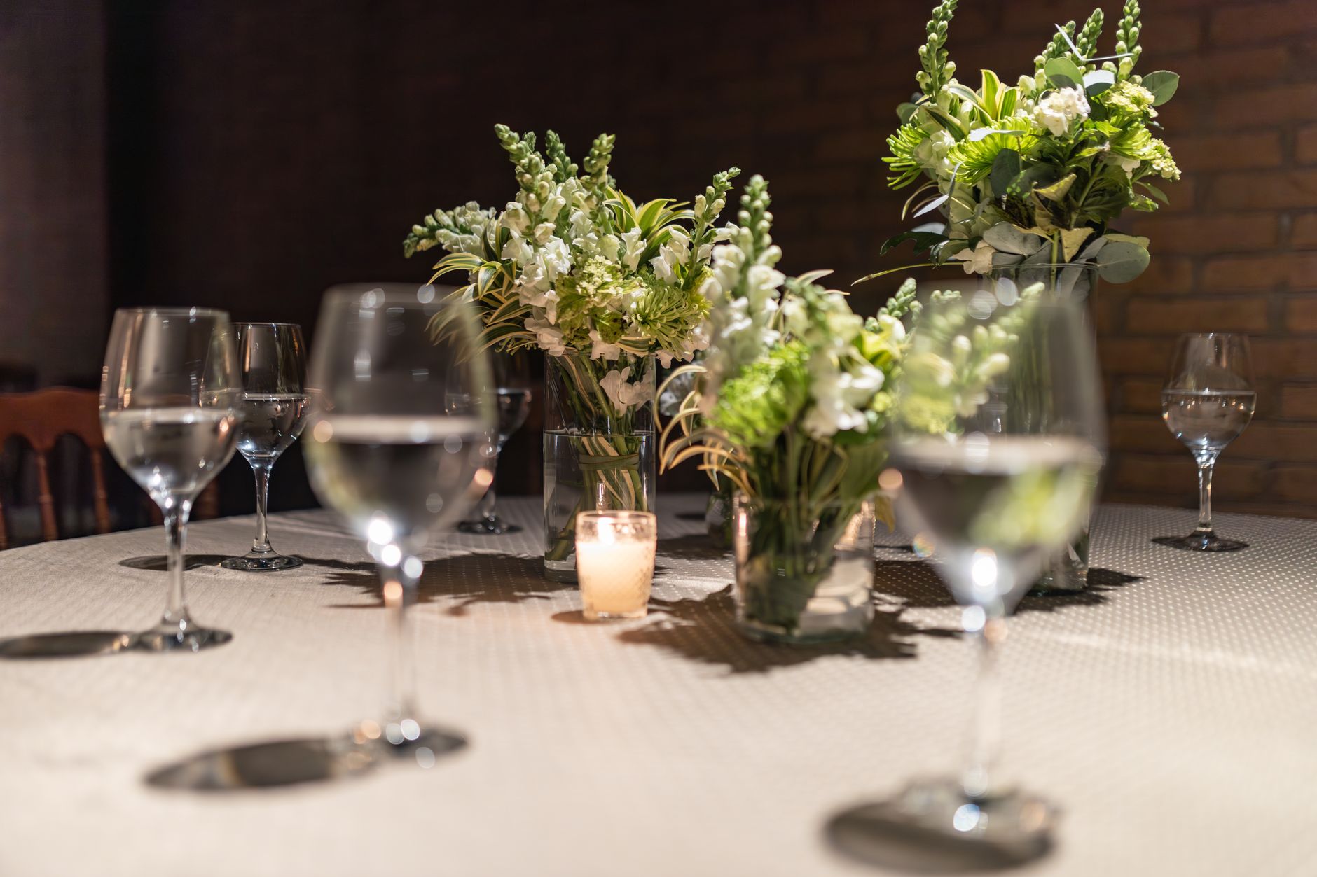 Beautifully decorated table with flowers and wine glasses in a restaurant setting.