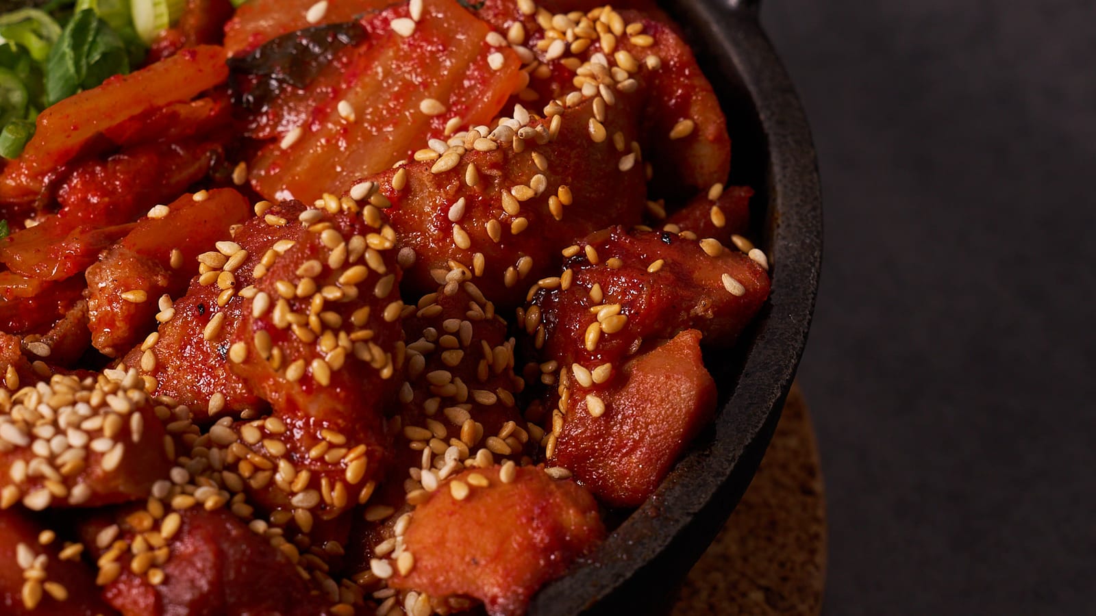 Kimchi and pork belly stir-fried in a cast-iron skillet with sesame seeds, scallions and shredded seaweed at 8282